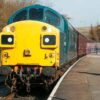 Class 37 loco in BR Blue colour scheme at the front of a passenger train on the East Lancs Railway