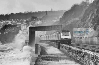 Winter storms pounding the seawall at Dawlish as a First Great Western passenger train passes
