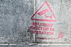 Protest graffiti spray painted on a block wall