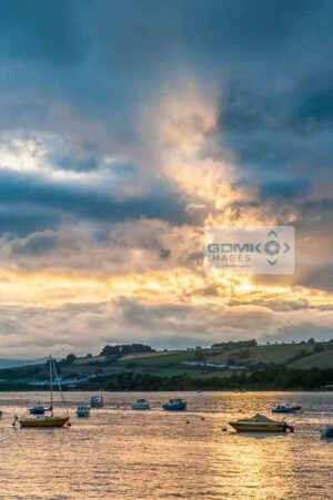 Sun breaking through dramatic clouds over the River Teign near shaldon