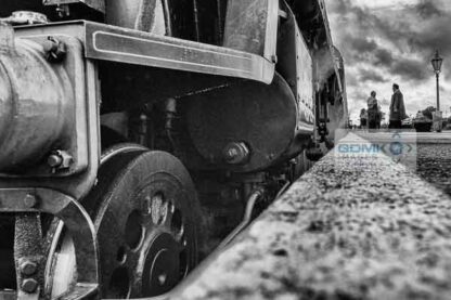 Platform level view of the front of a Bulleid Light Pacific steam loco standing in a platform in black and white