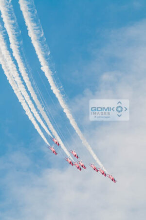 RAF Red Arrows flying in formation trailing white smoke