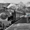 Steam train at Darley Dale Black and white view of the station master waiting on the platform at Darley Dale railway station as a passenger train arrives