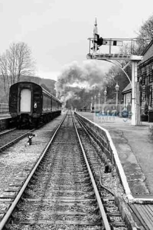 Black and white image of a steam train leaving Darley Dale railway station on the Peak Rail preserved railway